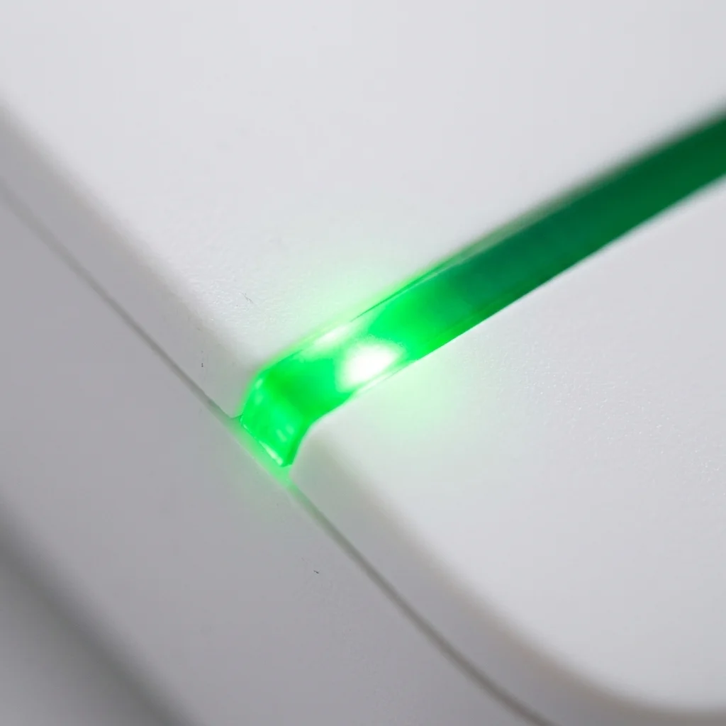 Macro close-up of active green LED status indicator light on ESaverWatt device